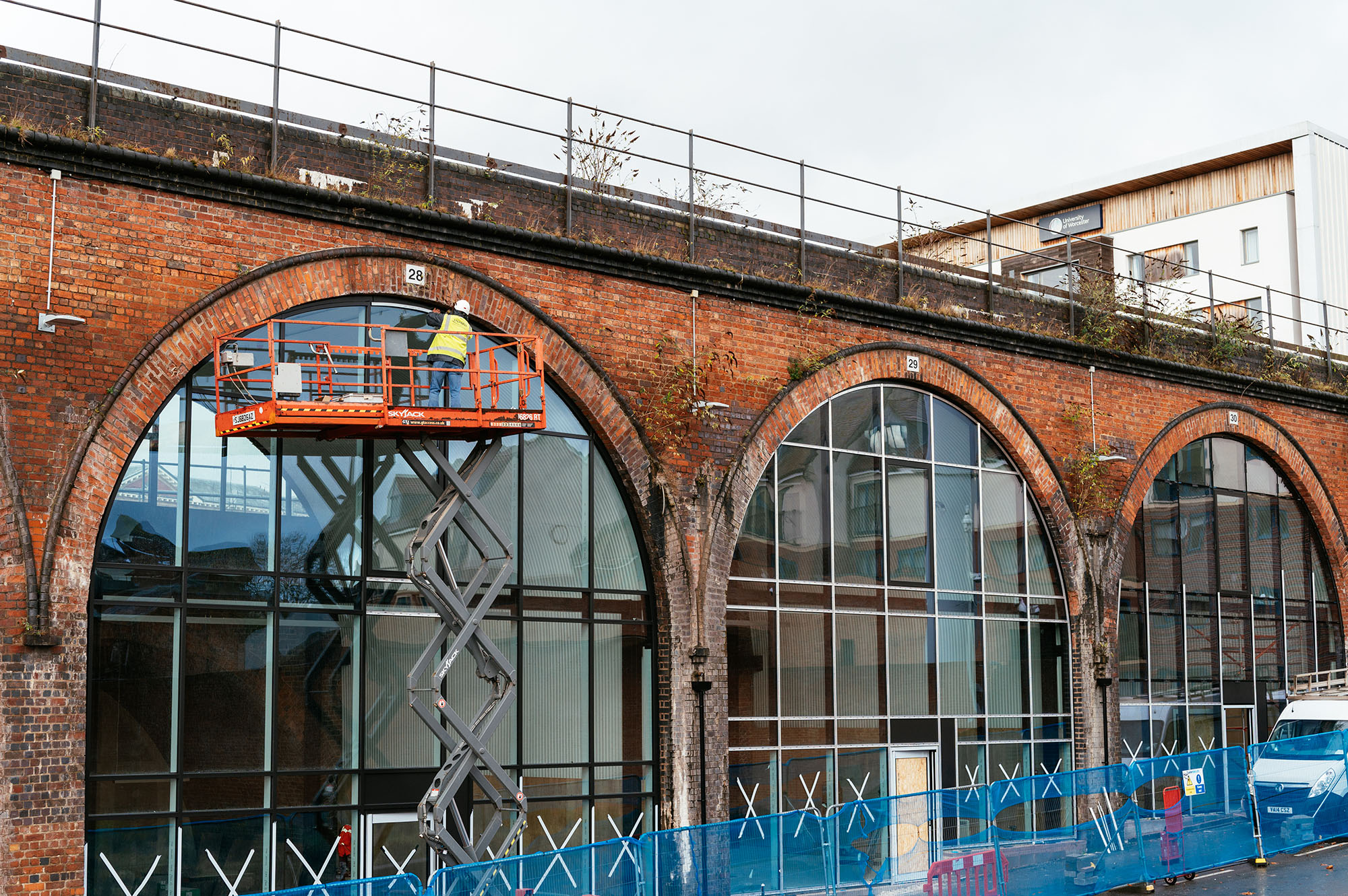 A worker on a raised platform working on the outside of the Arches